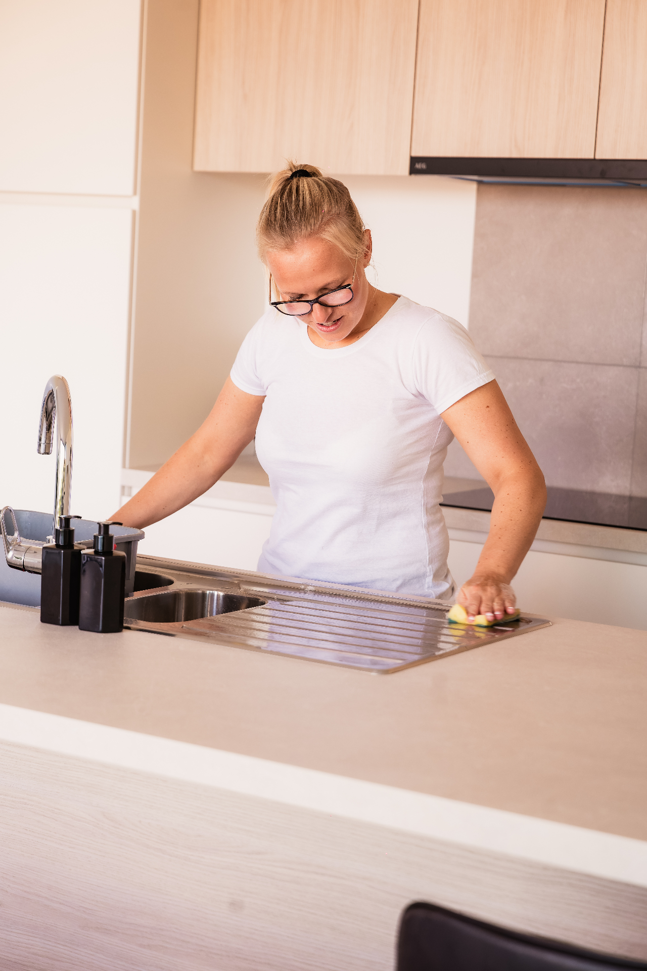 Anais poetst de aanrecht in een keuken